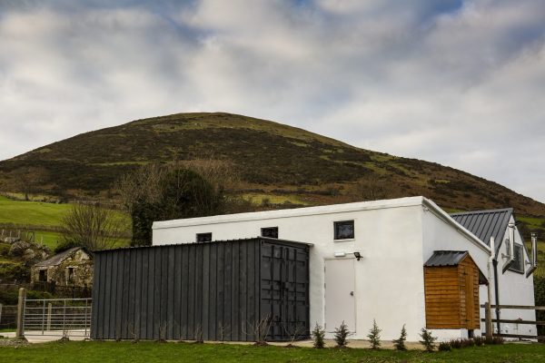 farmhouse with mountain in background