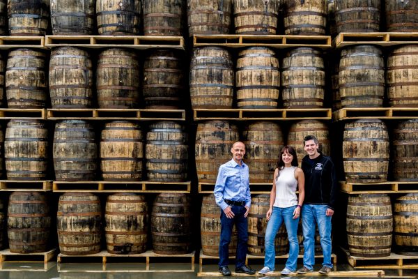 people in front of whiskey barrels