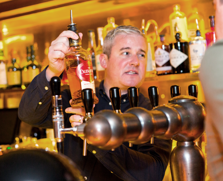 man showing whiskey bottle at tasting